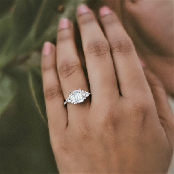 emerald three stone ring on hand